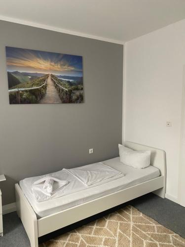 a bed in a room with a painting on the wall at GoldStar Apartments nähe Messe in Sarstedt