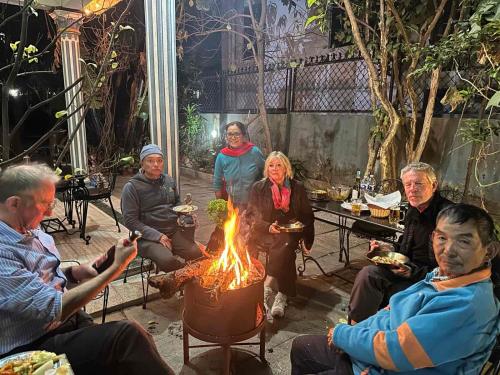a group of people sitting around a fire at Nepal Bed and Breakfast in Kathmandu