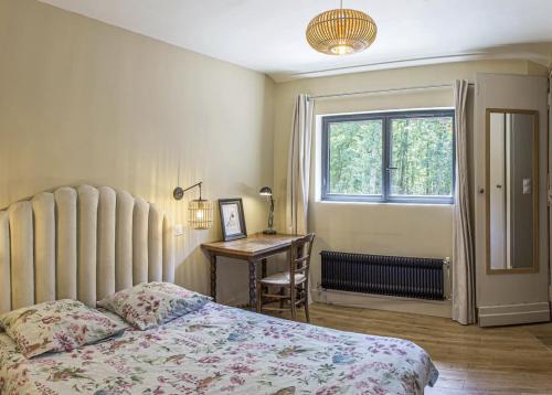 1 dormitorio con cama, escritorio y ventana en Lodge de Loire - rive gauche - proche Chambord, en Saint Laurent Nouan