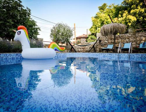 Una piscina con un cisne inflable en el medio. en Villa Komitata-Pool and Jacuzzi en Balchik