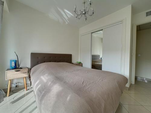 - un grand lit dans une chambre dotée d'un lustre dans l'établissement Appartement proche CARLTON, à Cannes
