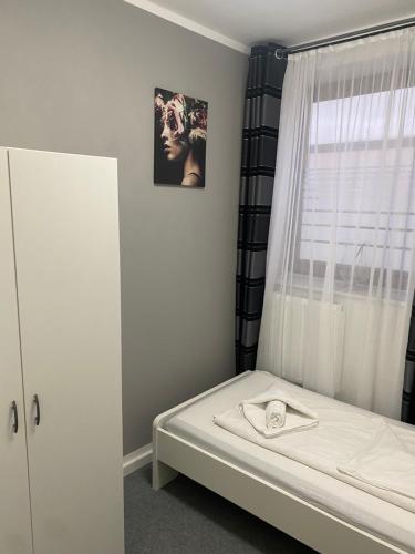 a small bedroom with a bed with a window at GoldStar Apartments nähe Messe in Sarstedt