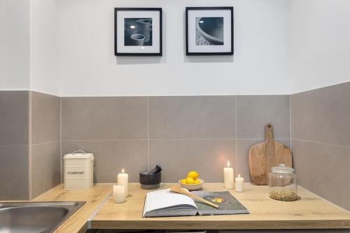 - un comptoir de cuisine avec des bougies et un évier dans l'établissement Brenne - 1 chambre à Montorgueil, à Paris