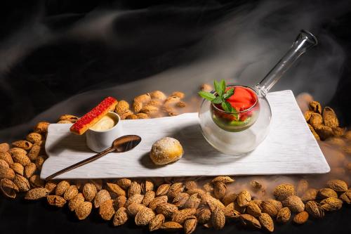 a plate of peanuts with a cocktail and a spoon at Migjorn Ibiza Suites & Spa in Playa d'en Bossa