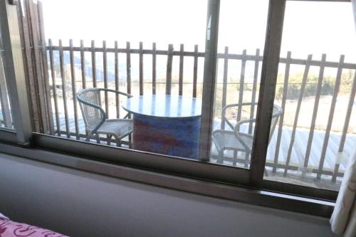 a table and chairs sitting on a balcony with a window at 星光山悦景觀民宿 in Heping