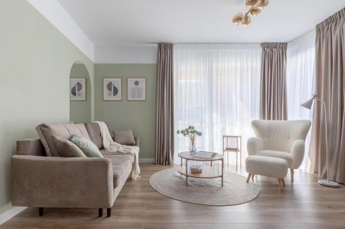 a living room with a couch and a chair and a table at Dream Garden Apartment - Free Parking - Welness Jacuzzi SPA in Sinaia