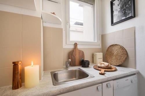 une cuisine avec un évier et une bougie sur un comptoir dans l'établissement Amalfi - Studio et terrace à Auteuil, à Paris