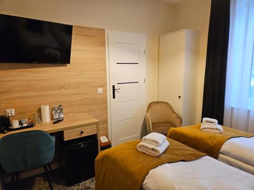 a hotel room with two beds and a desk and a television at ApartHotel Centrum - parking free in Białystok