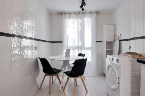 eine Küche mit einem Tisch und Stühlen sowie einer Waschmaschine in der Unterkunft Apartamento tropical boho piscina y vistas al mar - VISTA GOLF 25 in Estepona
