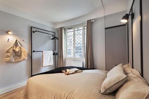 une chambre avec un grand lit et une fenêtre dans l'établissement Loches - 1 chambre à Mouffetard, à Paris