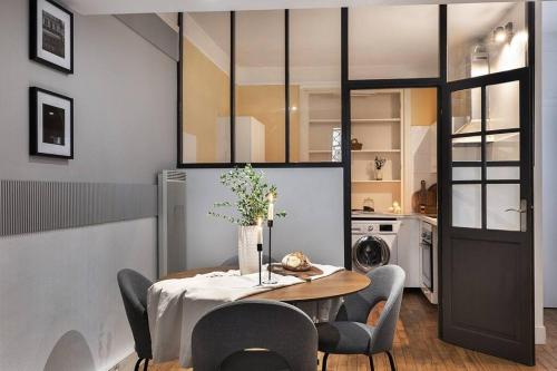 une salle à manger avec une table et des chaises et une cuisine dans l'établissement Loches - 1 chambre à Mouffetard, à Paris