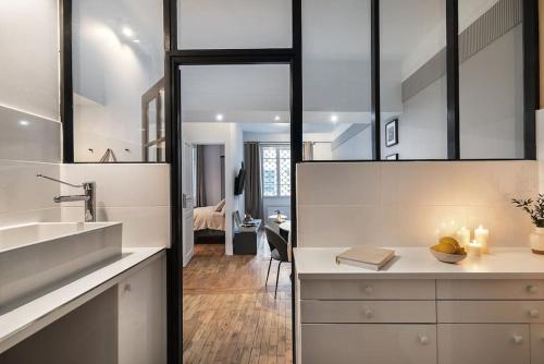 une cuisine avec un évier et un comptoir avec un miroir dans l'établissement Loches - 1 chambre à Mouffetard, à Paris