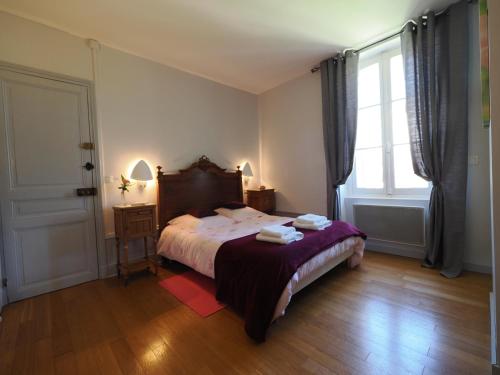 a bedroom with a bed with two towels on it at Le Jardin des Lys in La Roche-Posay