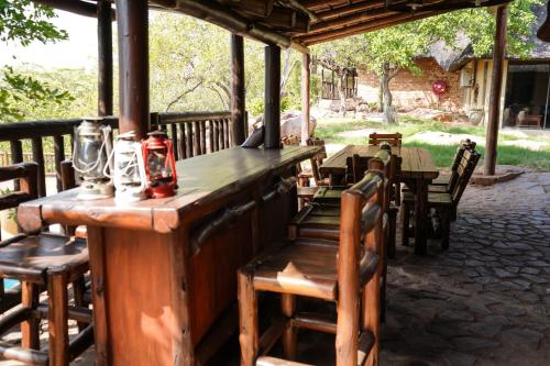 a wooden bar with chairs and tables in a patio at Lucca Lodge in Musina