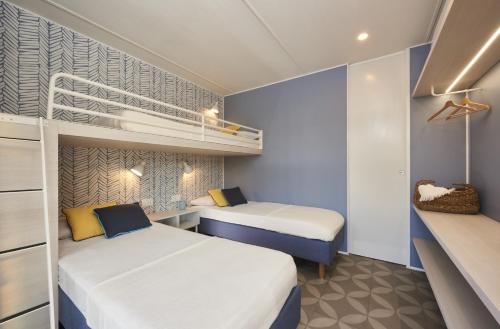 a bedroom with two beds and a bunk bed at Club del Sole Romagna Family Resort in Riccione