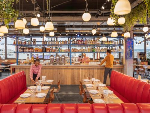 two people standing at the bar of a restaurant at Eklo Paris Expo Porte de Versailles in Vanves