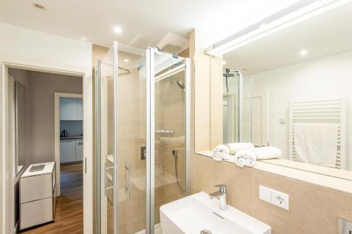 ein Bad mit einem Waschbecken und einem Spiegel in der Unterkunft Erich Johannsen Wai Whg 4 in Keitum