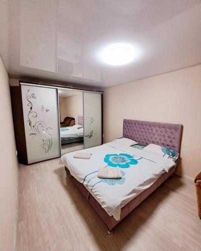 a bedroom with a bed and a mirror at Студия 2 комнаты в центре города in Kryvyi Rih