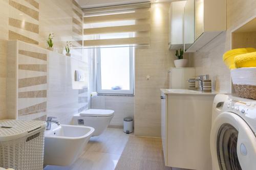 a bathroom with a sink and a washing machine at Apartment Marangunija in Malinska