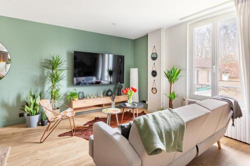 a living room with a couch and a tv at LRL 4 - Les Reflets du Loing - Nemours-Centre in Nemours
