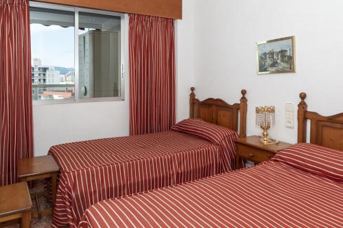 een hotelkamer met 2 bedden en een raam bij Florazar 2, Viii-8-B in Cullera