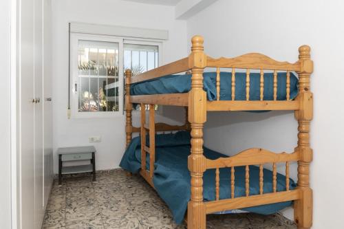 a wooden bunk bed in a room with a window at Hawai Bajo in Faro de Cullera