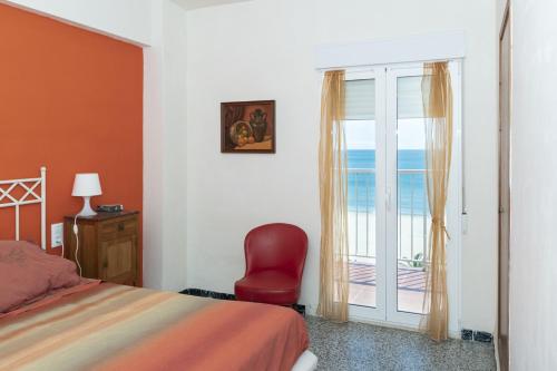 una camera con un letto, una sedia rossa e una finestra di Montemar, C-8º-22 a Cullera