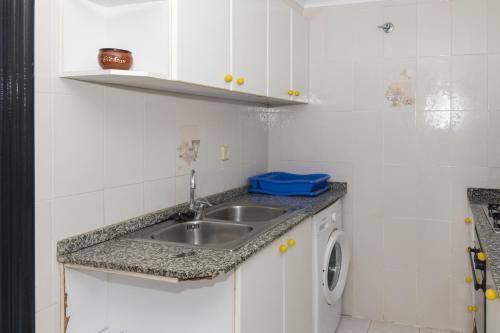 eine Küche mit einer Spüle und einer Waschmaschine in der Unterkunft Dosel, 6º-30 in Cullera