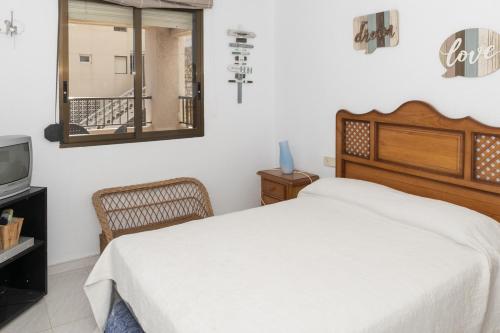 ein Schlafzimmer mit einem Bett, einem Spiegel und einem TV in der Unterkunft Dosel, 6º-30 in Cullera