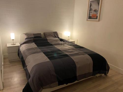 ein Schlafzimmer mit einem großen Bett mit zwei Nachttischen in der Unterkunft Chez Papou in Bastogne