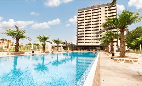 une grande piscine avec un hôtel en arrière-plan dans l'établissement Europe Hotel & Casino All Inclusive, à Sunny Beach