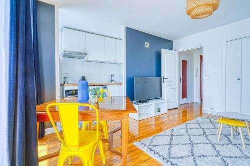 uma cozinha com uma mesa de madeira e cadeiras amarelas em Studio cosy et calme au 1er étage avec balcon à 15 min du RER A em Fontenay-sous-Bois