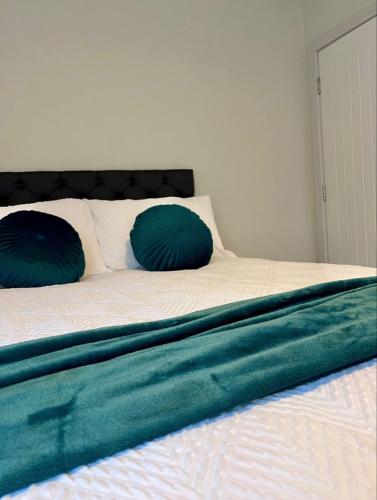 a bed with two blue pillows on top of it at Studios 21- By Eazy Rooms in Hessle