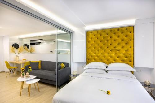 a bedroom with a large bed with a yellow headboard at Live Your Myth in Thissio in Athens
