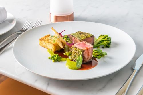 a white plate with food on a table at JA Palm Tree Court, Dubai in Dubai