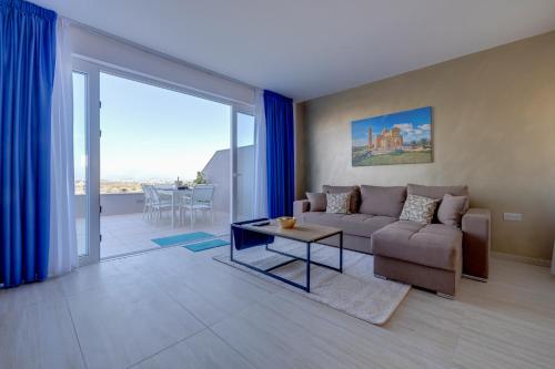 a living room with a couch and a table at Salmar Court Holiday Apartments with Pool by Buena Vista in Hal Ghaxiak