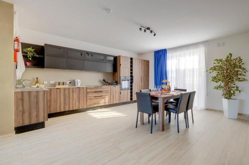 a kitchen and dining room with a table and chairs at Salmar Court Holiday Apartments with Pool by Buena Vista in Hal Ghaxiak