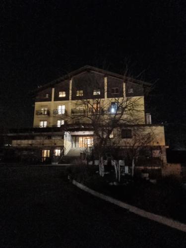 un gran edificio por la noche con sus luces encendidas en Appartamento Crihana, en Aosta