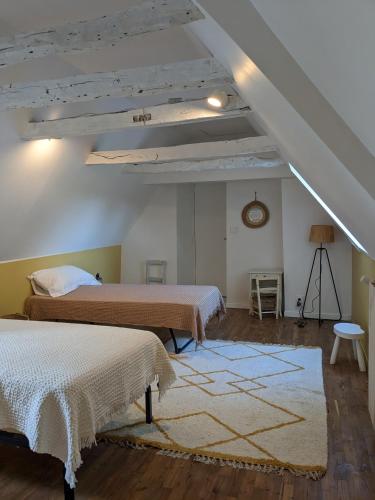 une chambre avec deux lits et un tapis dans l'établissement Les Pierres Lotoises- le cottage, à Reilhaguet
