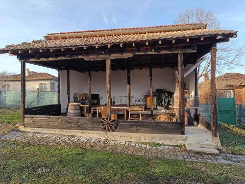 a wooden gazebo with a wooden table at Sunny Guest House in Boykovtsi
