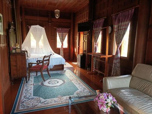 uma sala de estar com uma cama e um sofá em Ayutthaya teak home Homestay em Phra Nakhon Si Ayutthaya