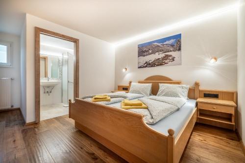 a bedroom with a wooden bed and a bathroom at Rickys Apartment Flachau in Flachau