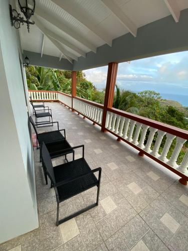 a row of benches sitting on a balcony overlooking the ocean at LE BLANC HIDEAWAY in Laborie