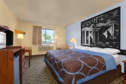 a hotel room with a bed and a flat screen tv at Super 8 by Wyndham Lynchburg VA in Lynchburg