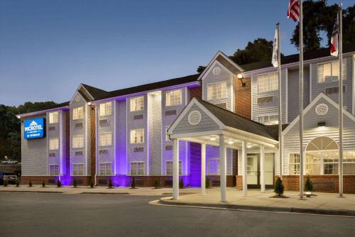 un grande edificio con luci viola di fronte di Microtel Inn & Suites by Wyndham Raleigh a Raleigh