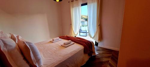 een slaapkamer met een bed met twee handdoeken erop bij Élégance Corse : Maison 3 chambres, Piscine in Figari