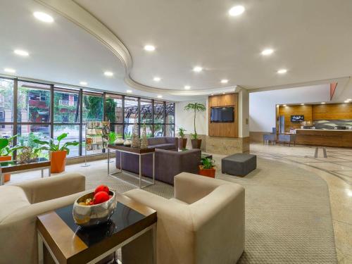 a living room with a couch and chairs and a table at Mercure Curitiba Golden in Curitiba