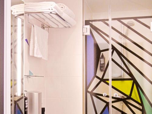 パリにあるイビス スタイルズ パリ メーヌ モンパルナスのバスルーム(タオル掛け、シャワー付)
