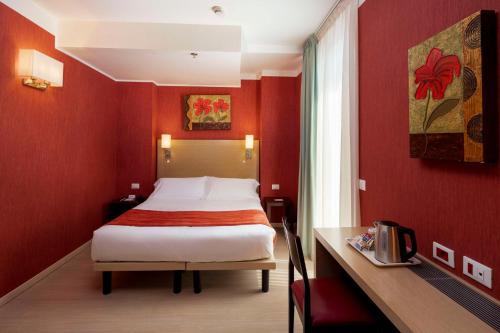 ein Schlafzimmer mit einem Bett in einem roten Zimmer in der Unterkunft Best Western Porto Antico in Genua