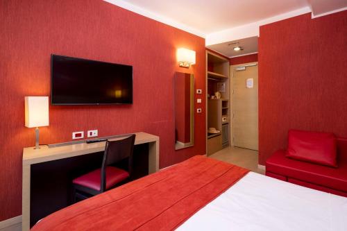 a red room with a bed and a desk and a tv at Best Western Porto Antico in Genova